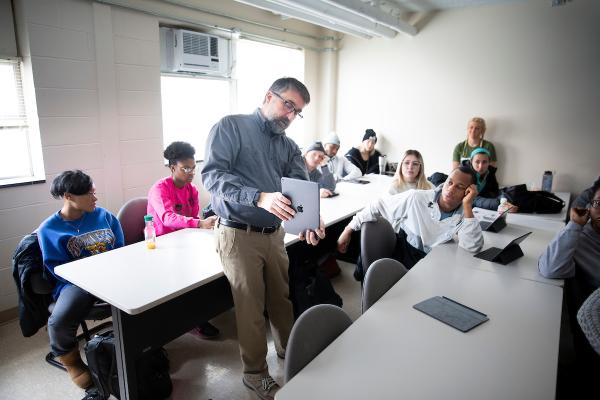 An instructor points to information on an iPad to a small class.